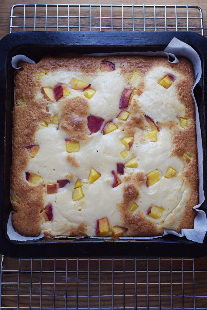 Baked peach cake in a square cake pan.