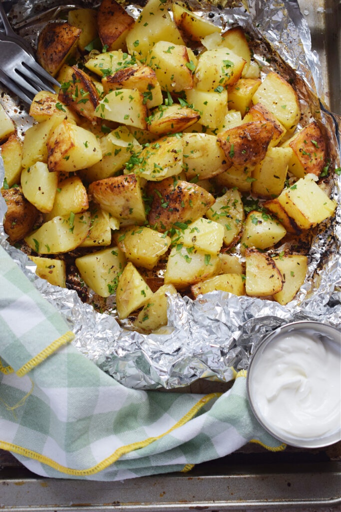 Grilled potatoes in tin foil with a dip.