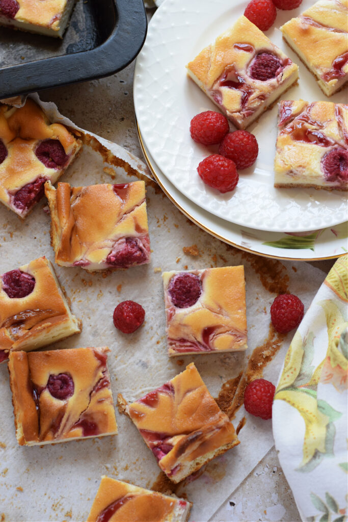 Raspberry cheesecake bars on a plate.