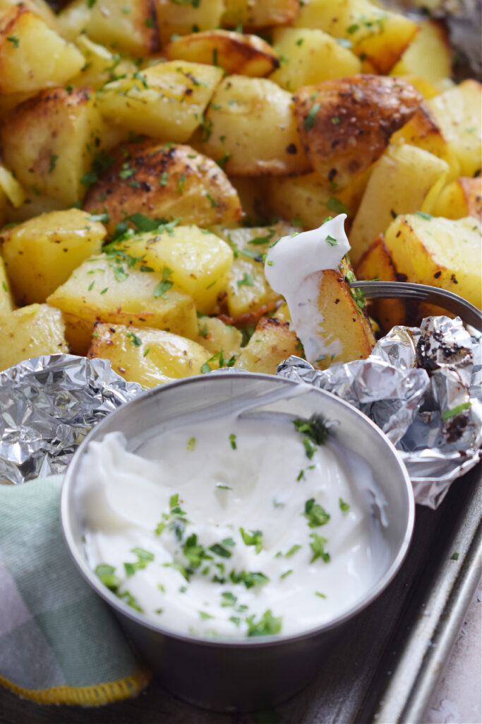 Close up of grilled potatoes with a dip.