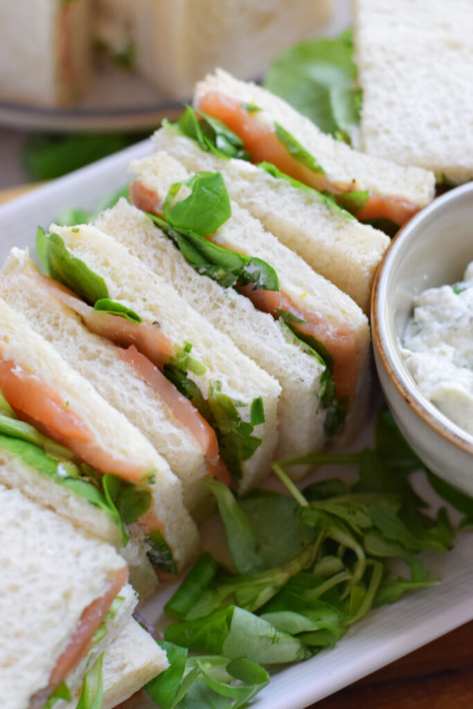 Smoked salmon tea sandwiches on a plate.