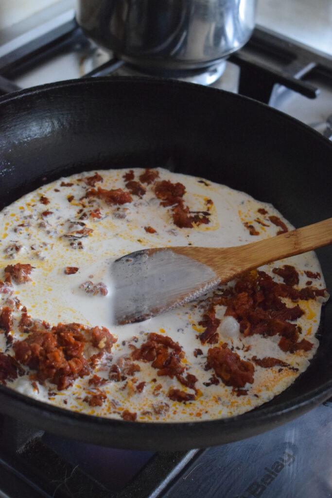 Making a creamy sun dried tomato sauce.