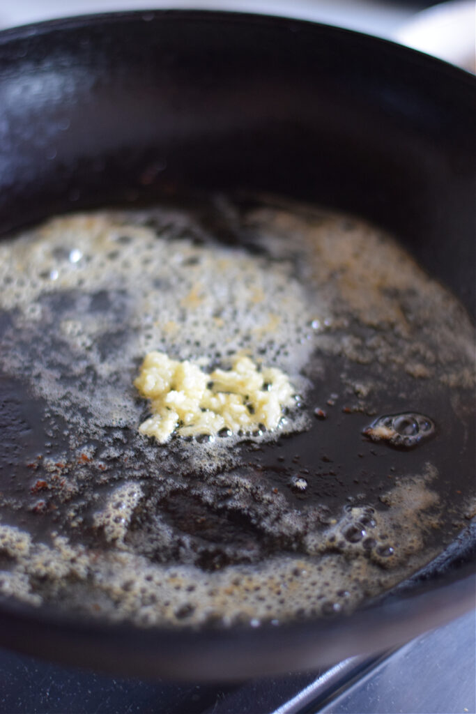 Cooking butter and garlic in a skillet.