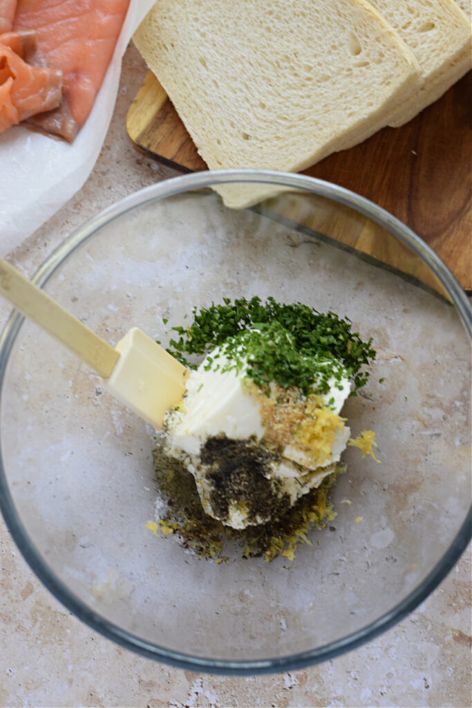 Making a herb cream cheese filling in a bowl.