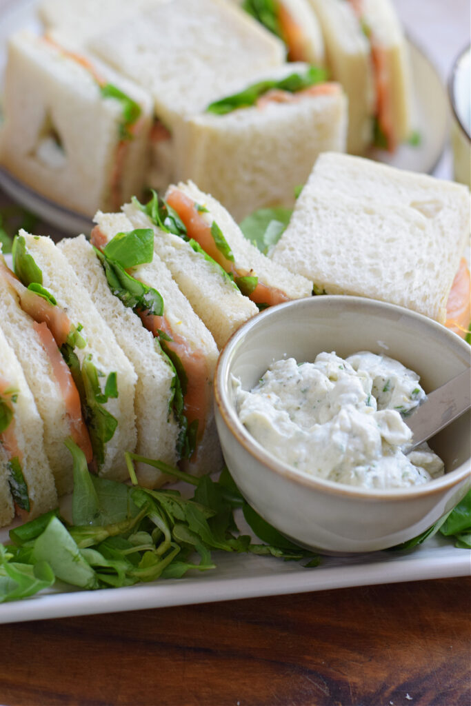 Smoked salmon tea sandwiches on a plate.