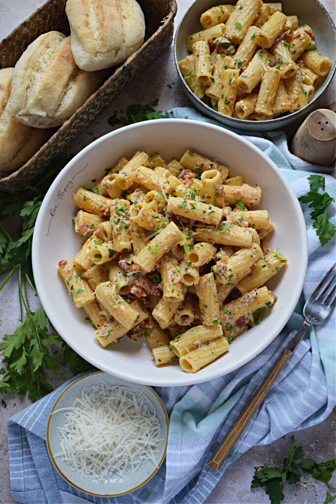 Bowls of pasta on a table with a tea towel.