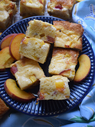 Peach cake squares on a blue plate.