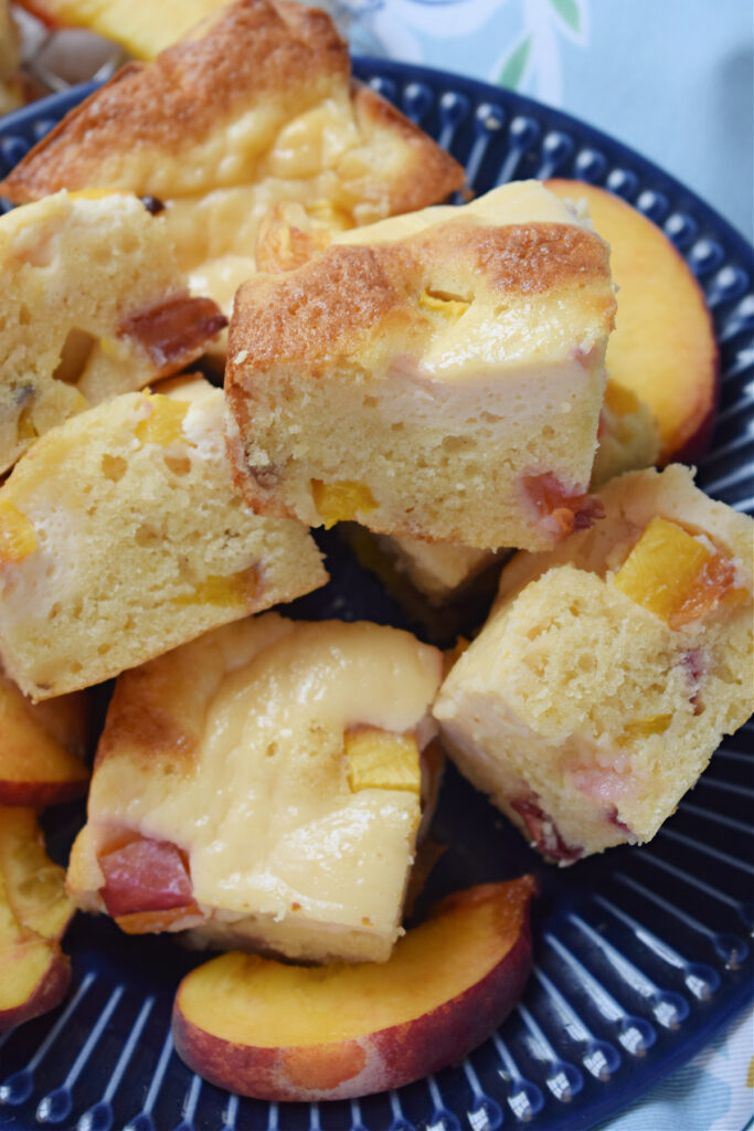 Close up of peach cake squares on a blue plate.