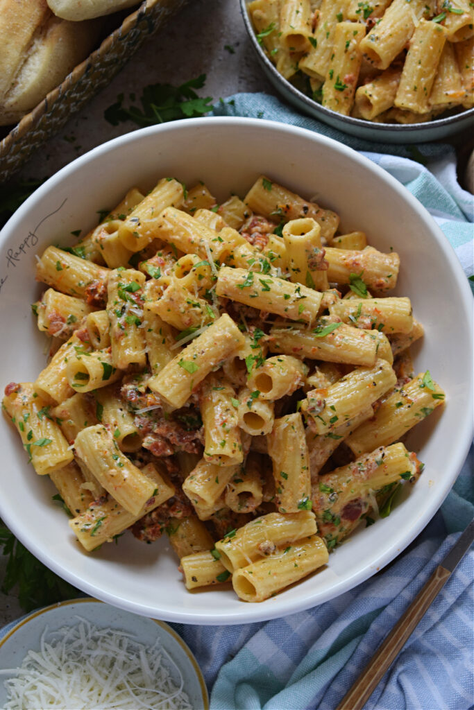 Pasta in a bowl with sun dried tomatoes.