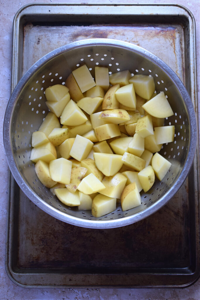 Cut potatoes in a colander.