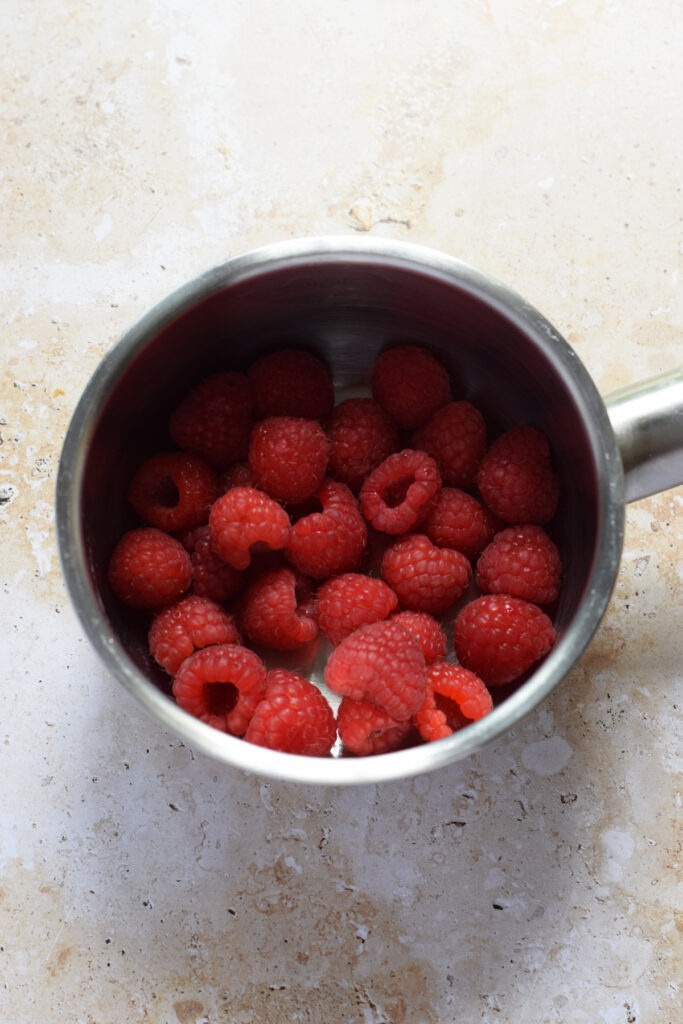 Fresh raspberries in a saucepan.