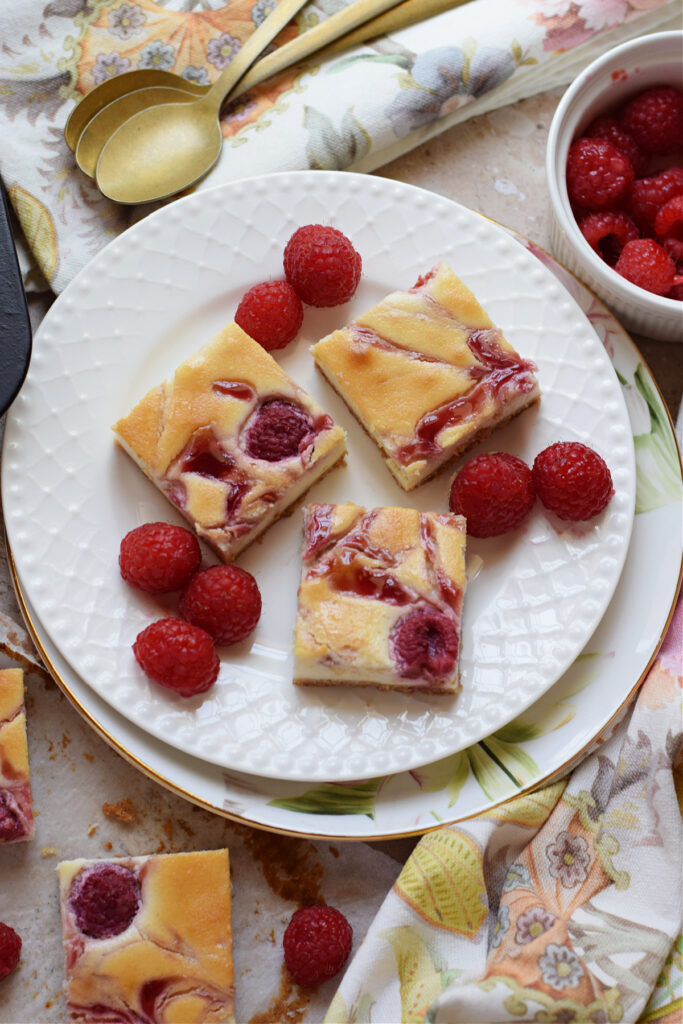 Raspberry cheesecake bars on a plate.