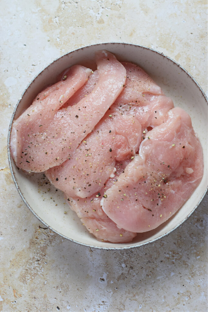 Seasoned turkey cutlets with salt and pepper.