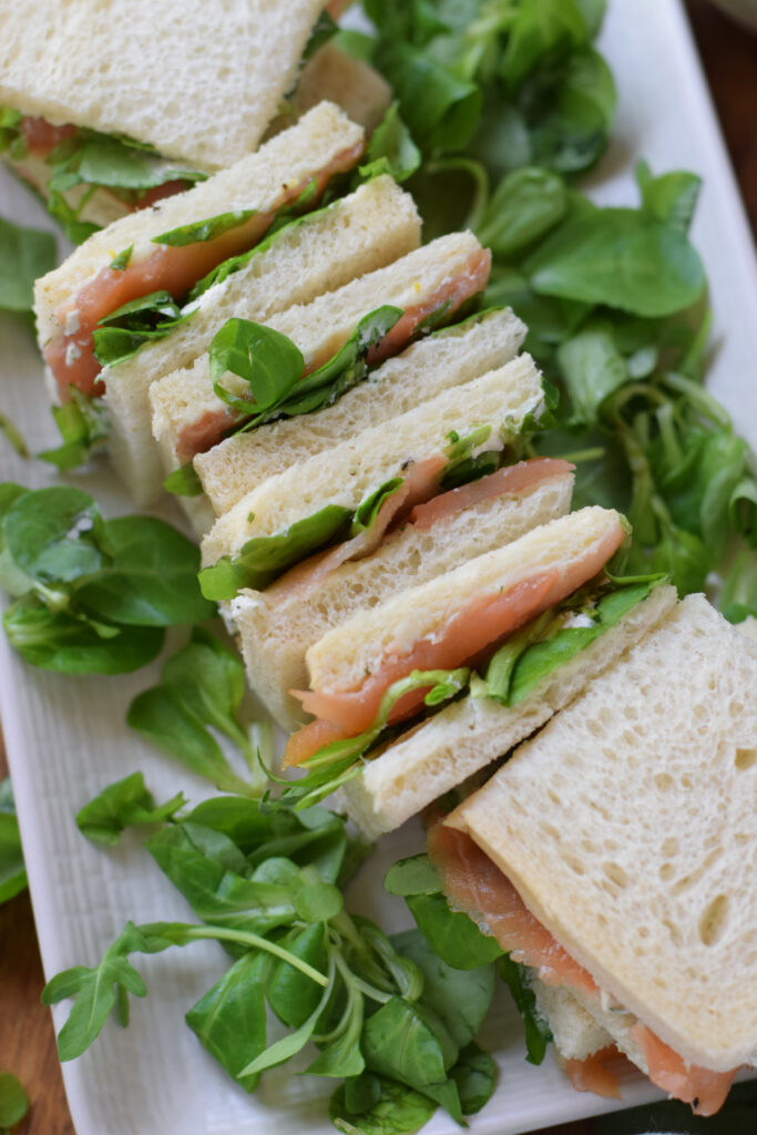 Smoked salmon sandwiches on a plate.