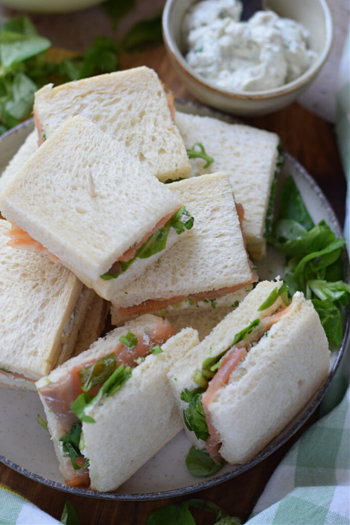 Smoked salmon sandwiches on a plate.
