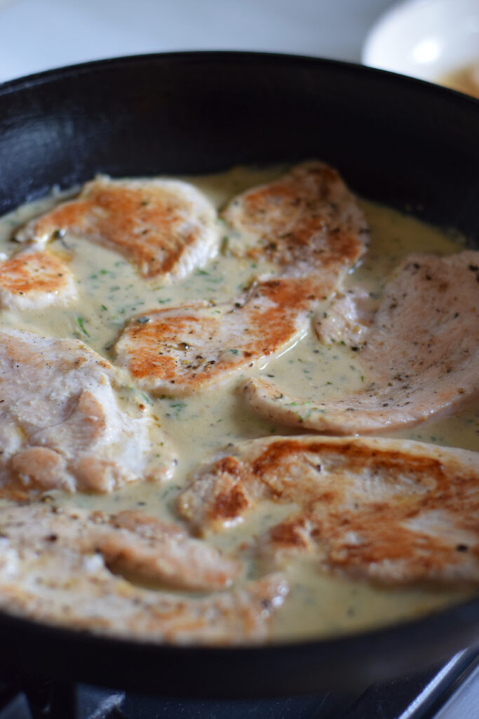 Cooking turkey cutlets in a sauce.