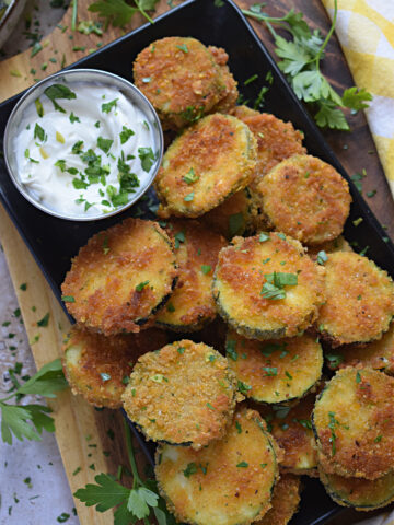 Panko crusted zucchini on a tray with a dip.