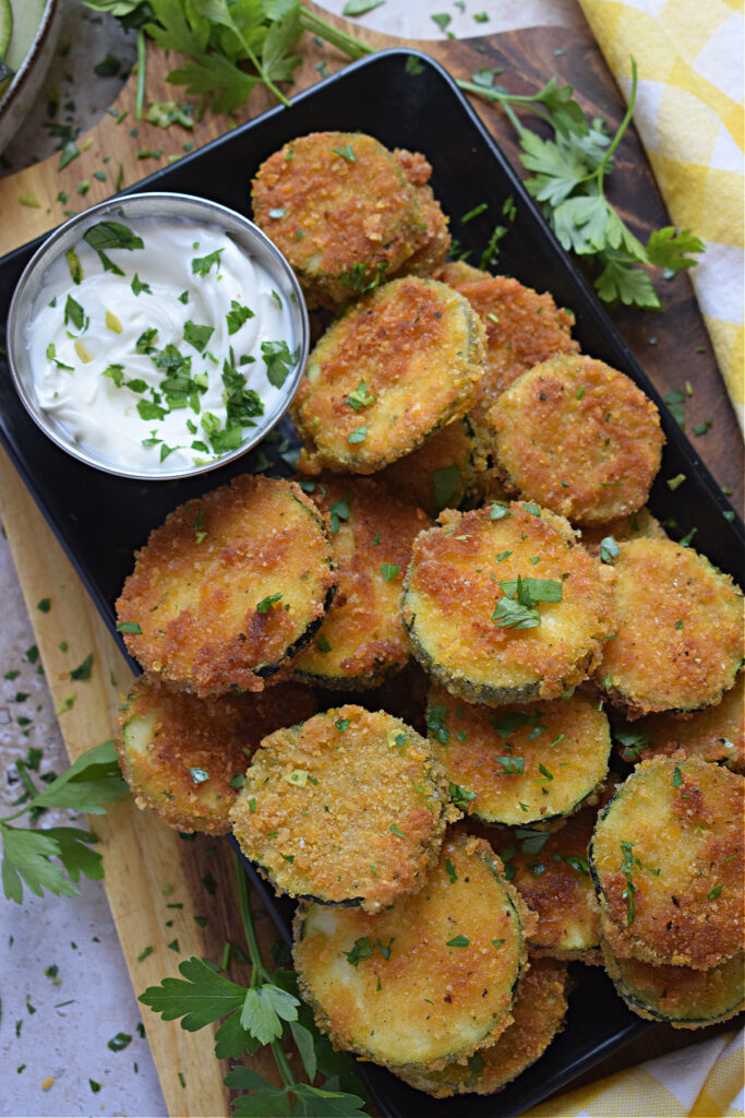 Panko crusted zucchini on a tray with a dip.