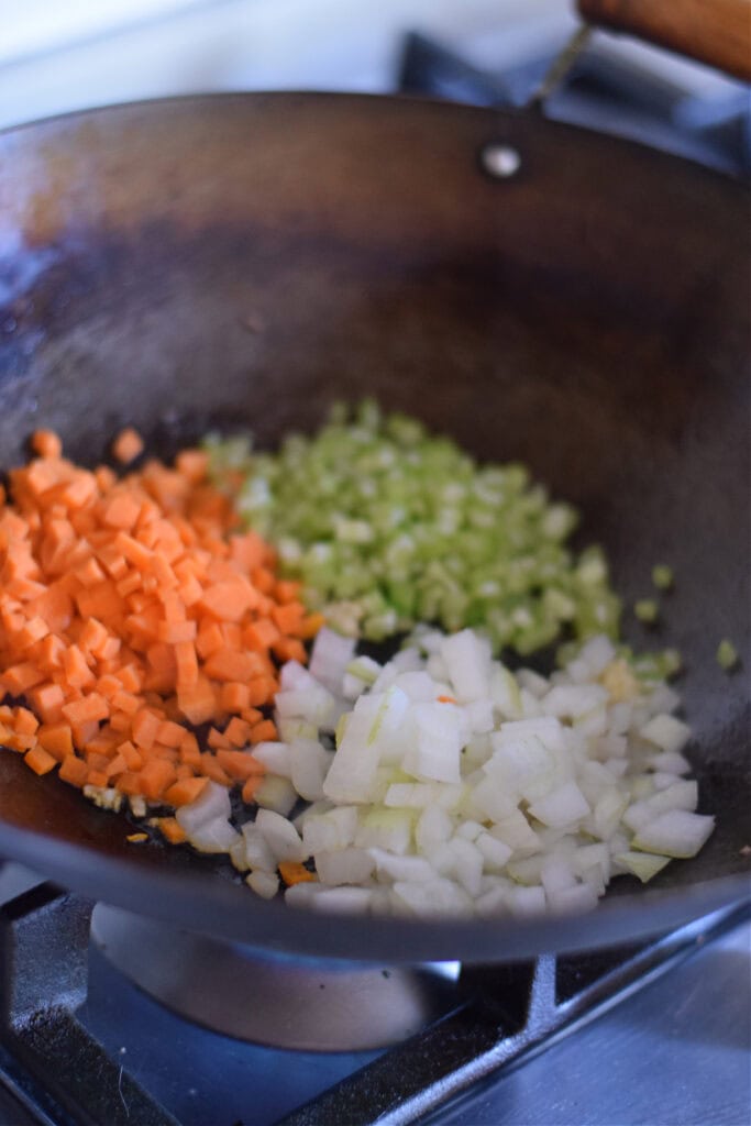 Adding vegetables to a wok.