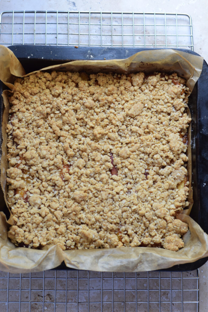 Baked peach crumble squares in a baking dish.