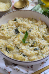 Close up of zucchini risotto in a white bowl.
