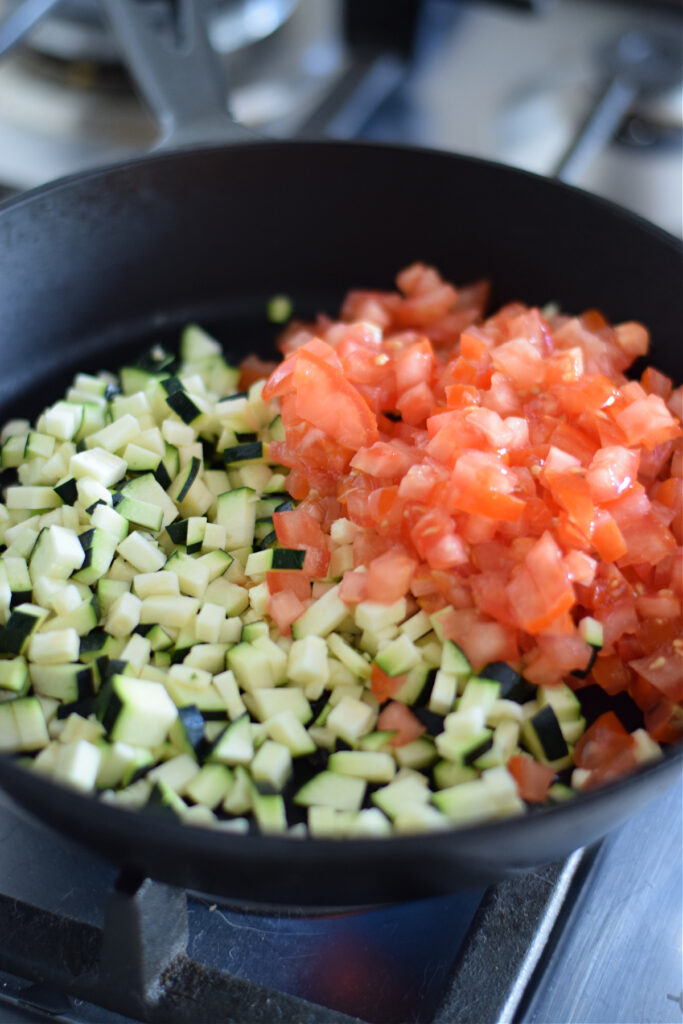 Tomatoes and zucchini in a skillet.