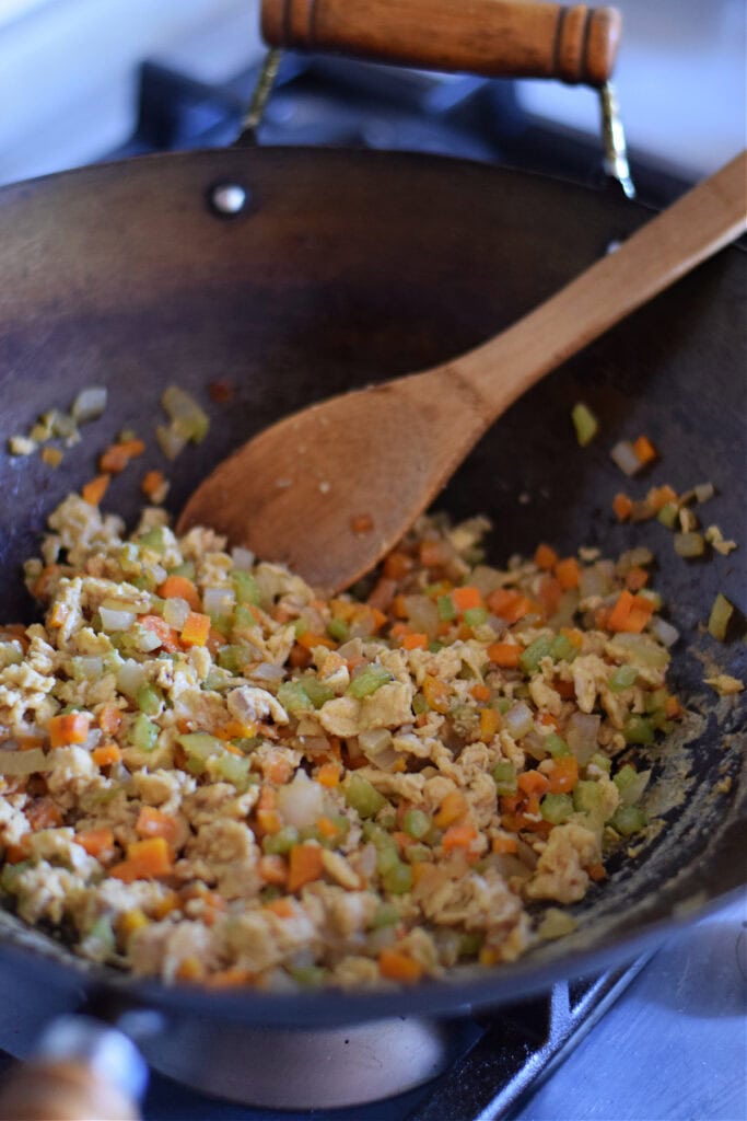 Stir fried eggs and vegetables in a wok.