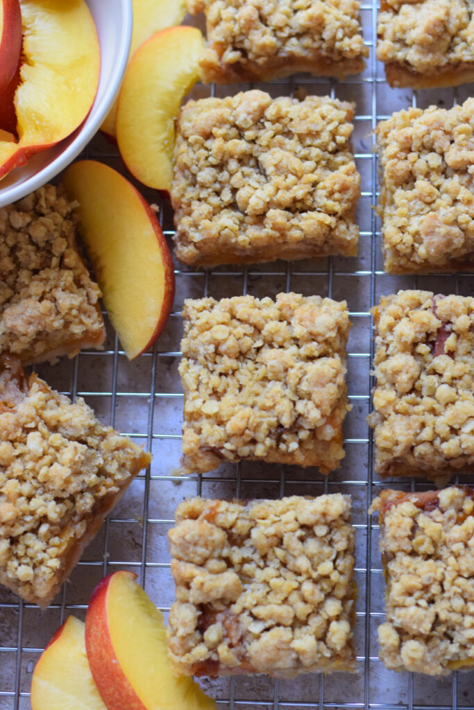 Peach crumble bars on a cooling rack.