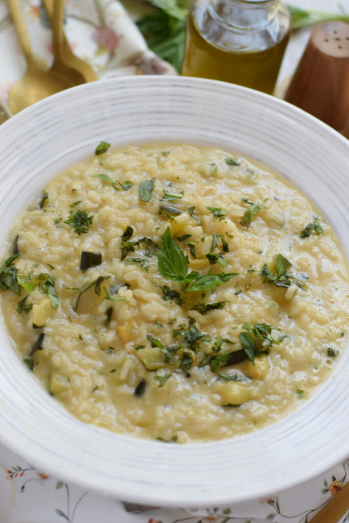 Creamy zucchini risotto in a white serving bowl.