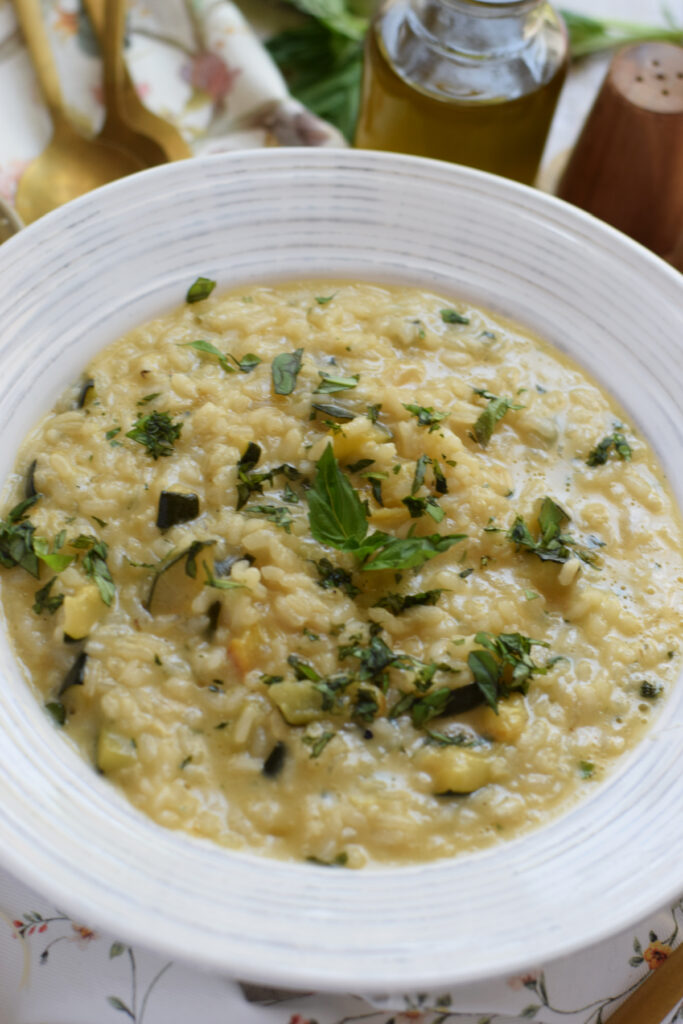 Close up of zucchini risotto in a white bowl.