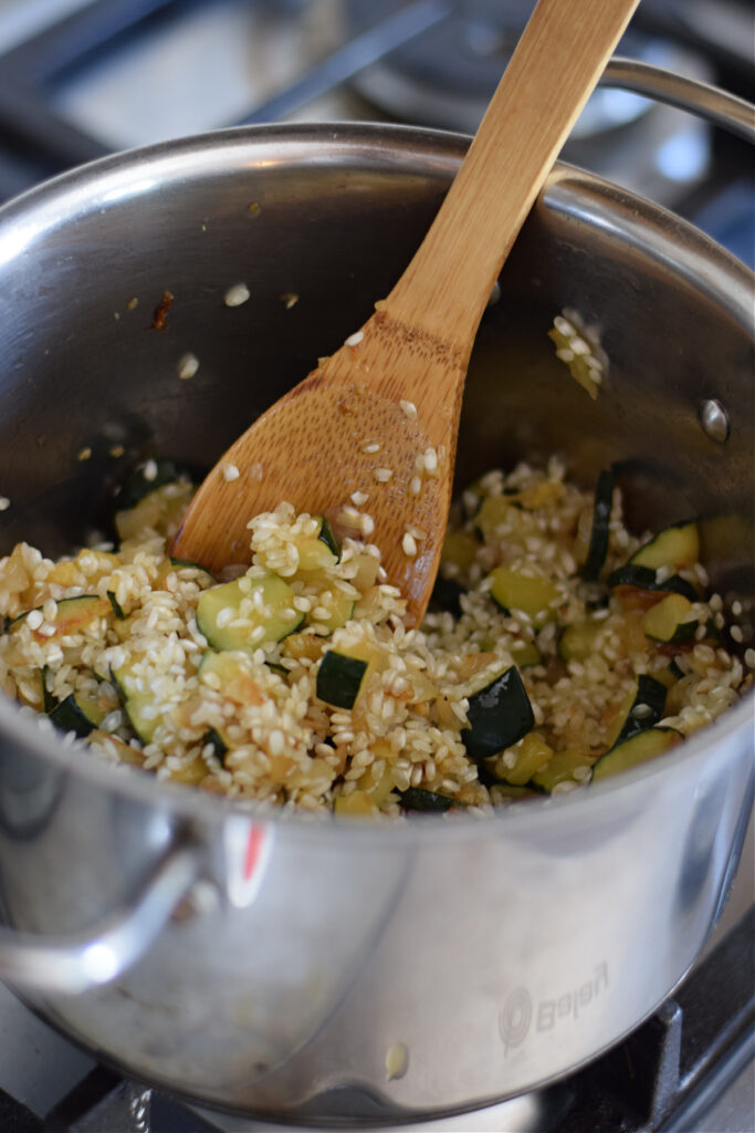 Cooking rice with zucchini in a pot.