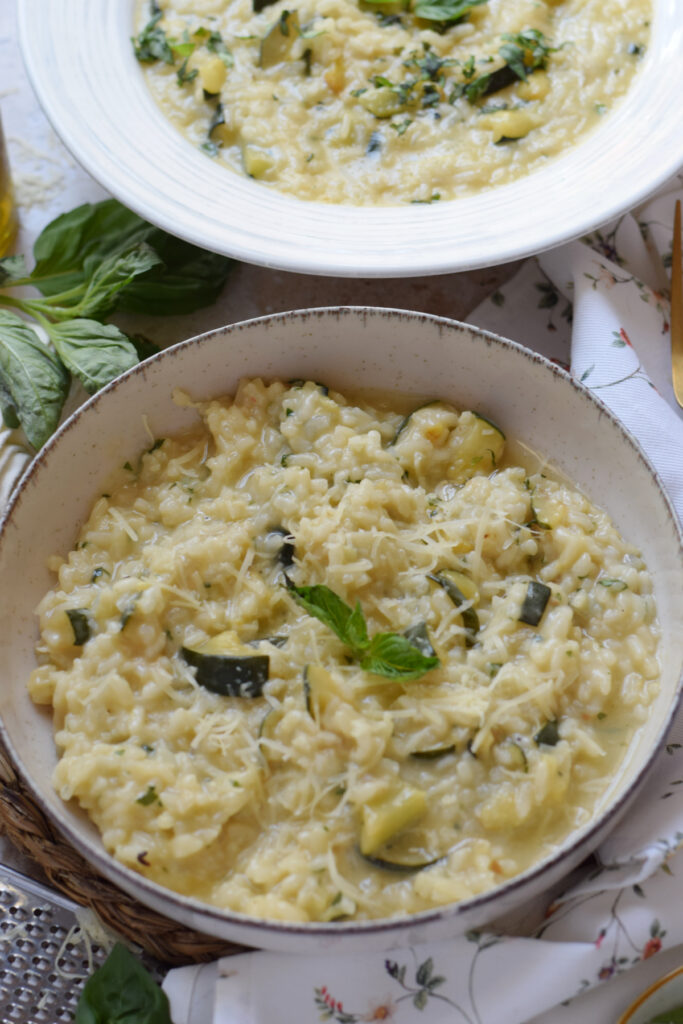 Creamy zucchini risotto in a white bowl.