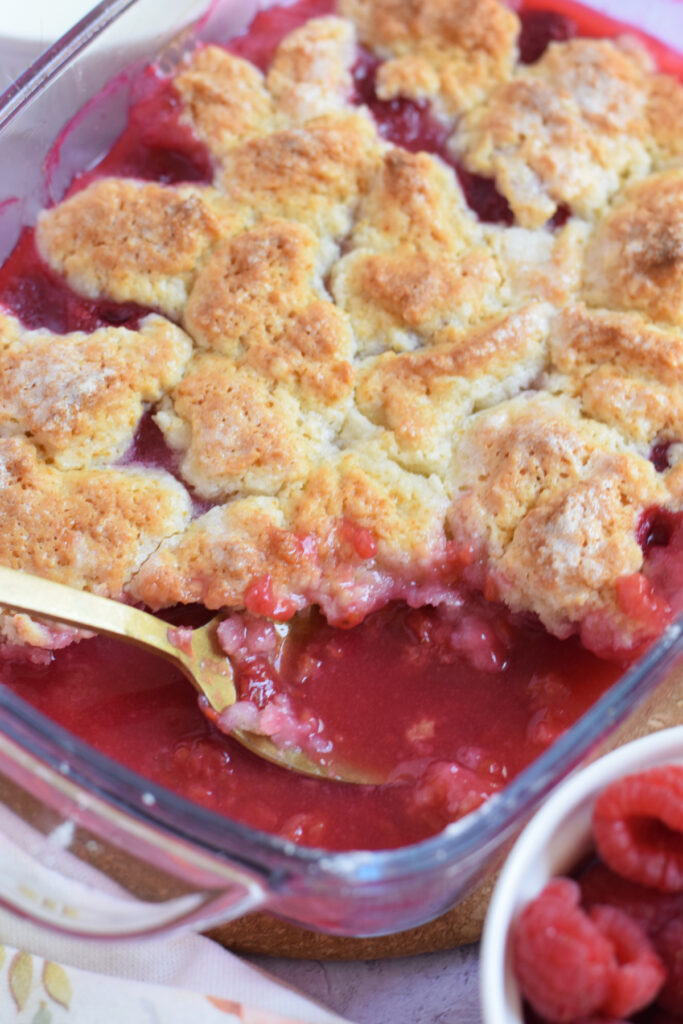 Close up of a raspberry cobbler in a glass dish.