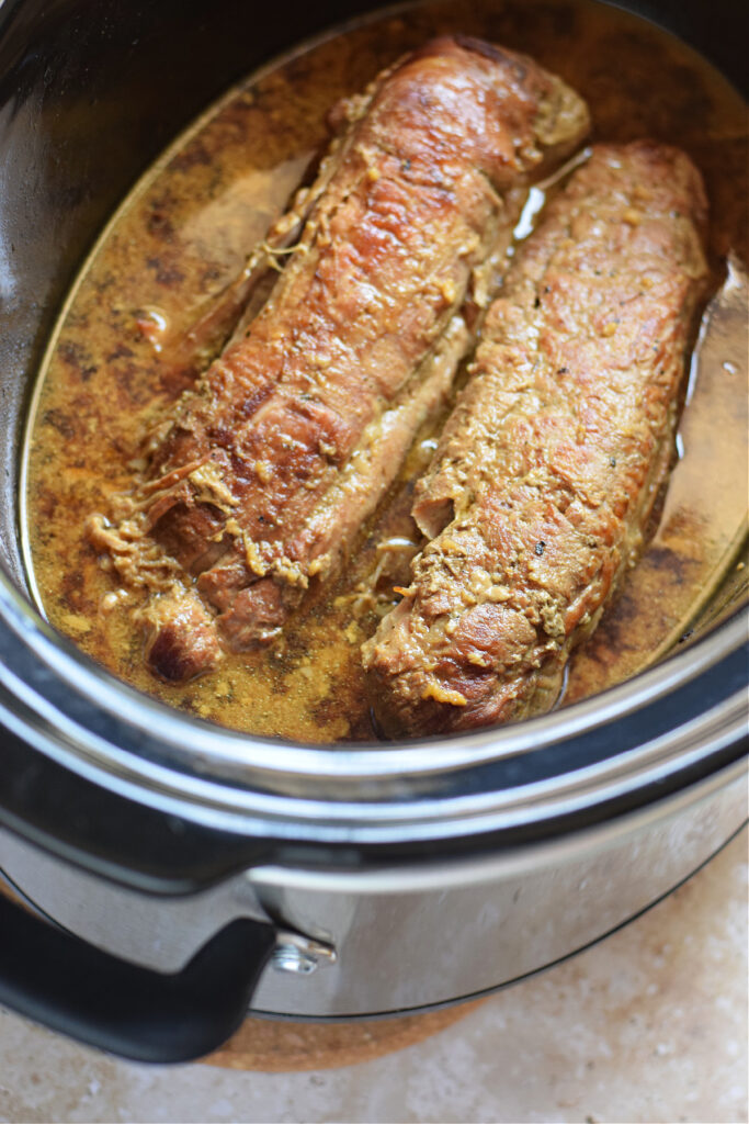 Cooked pork tenderloin in a slow cooker.