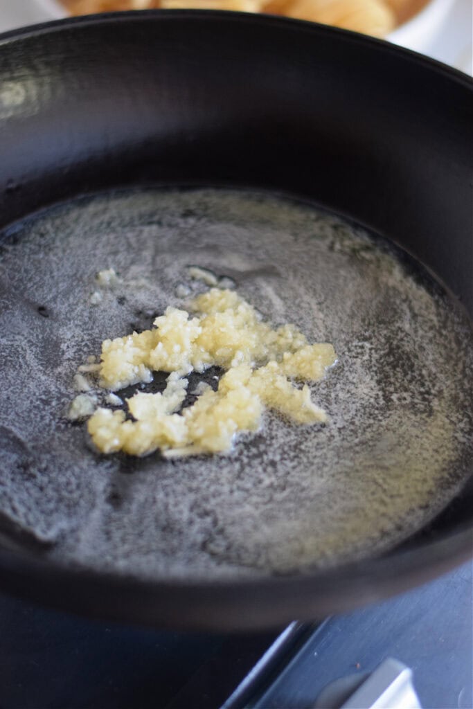Cooking garlic in butter in a skillet.