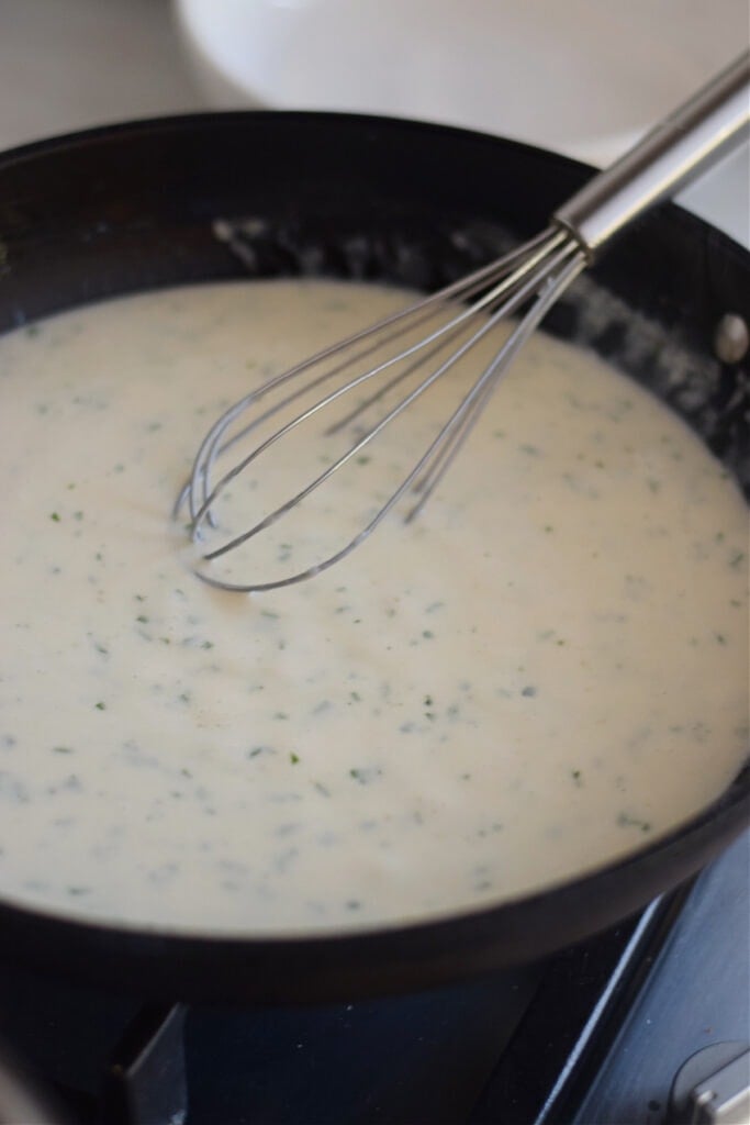 Creamy cheese sauce in a black skillet.