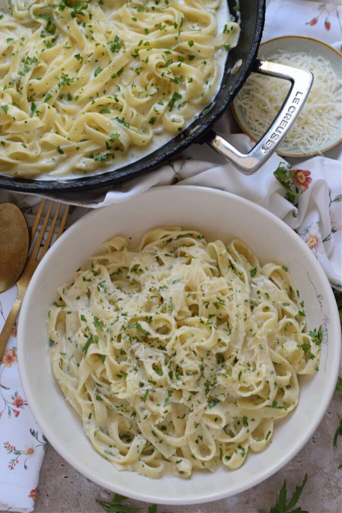 Creamy garlic pasta in a white bowl image.