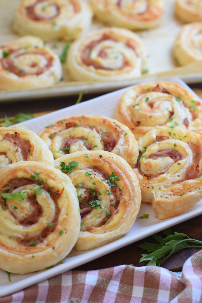 Ham and cheese pinwheels on a white plate.