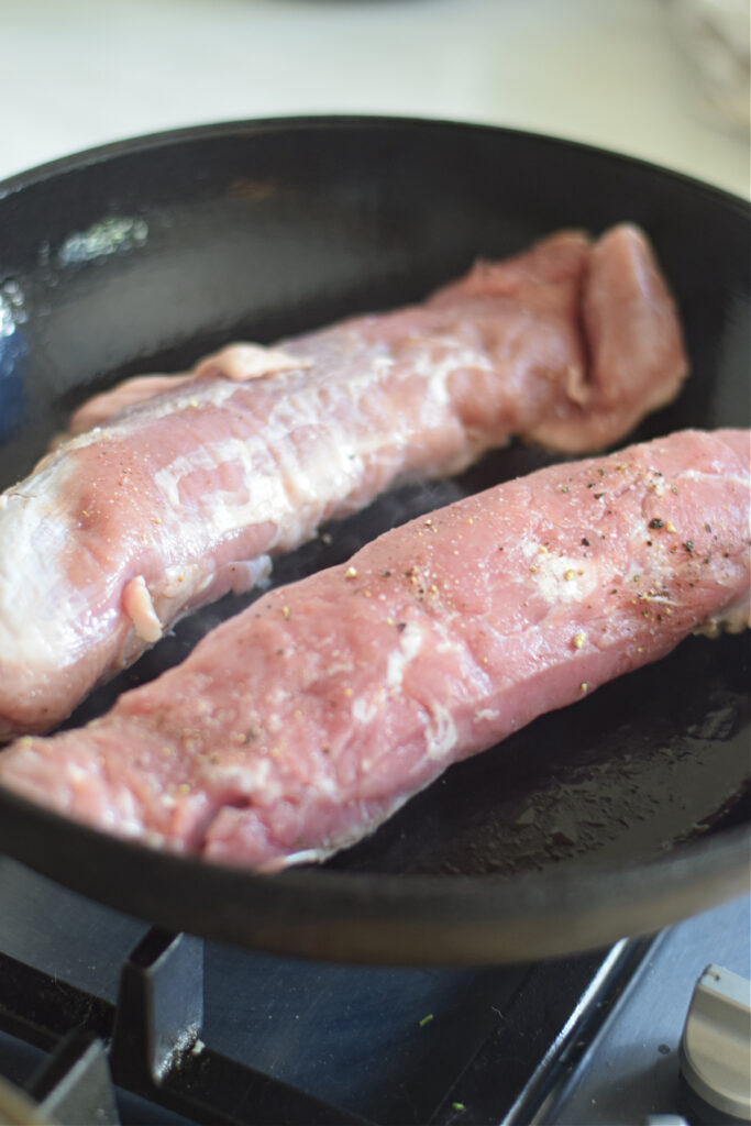 Cooking pork in a skillet.