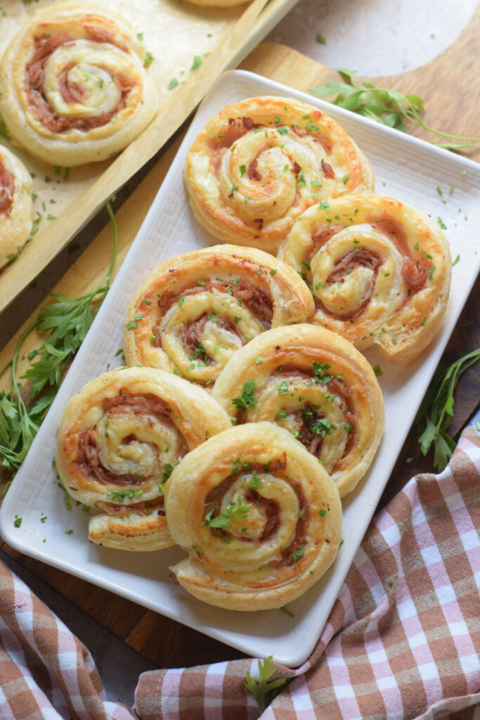Ham and cheese pinwheels on a white tray.