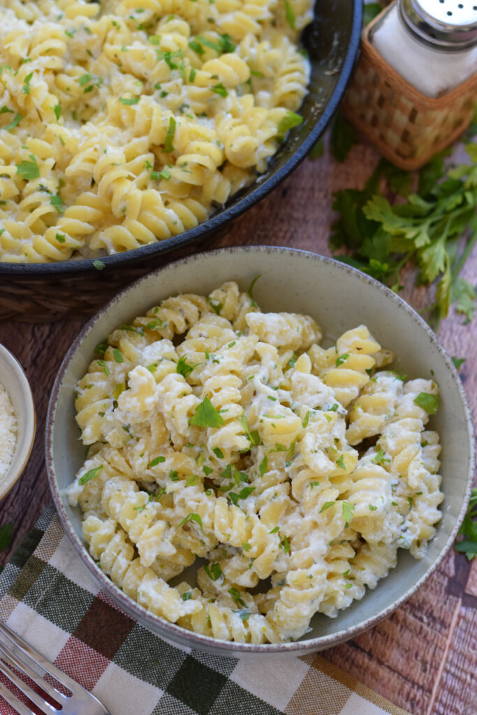Creamy pasta in a bowl and a skillet.