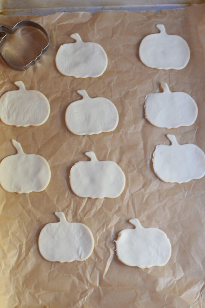 Halloween puff pastry shapes on parchment paper.
