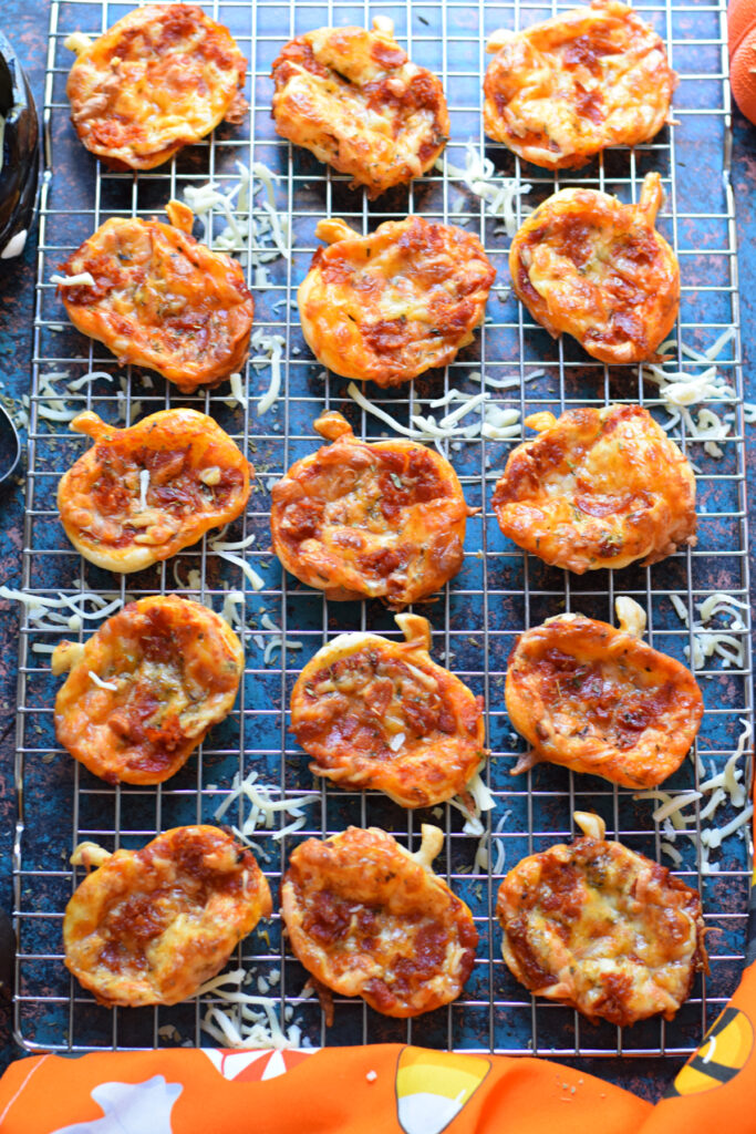 Halloween mini pizzas on a cooling rack.