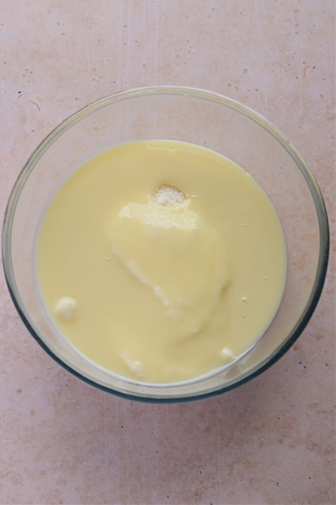 Condensed milk and coconut in a glass bowl.