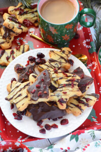 Dark chocolate shortbread cookies on a plate with a cup of coffee.