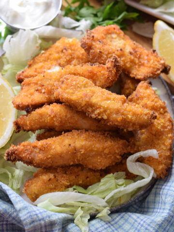 Crispy chicken with lemon wedges.