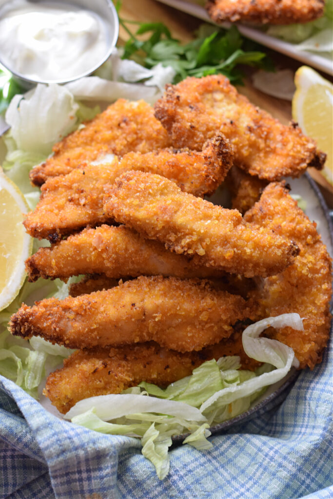 Crispy chicken with lemon wedges.