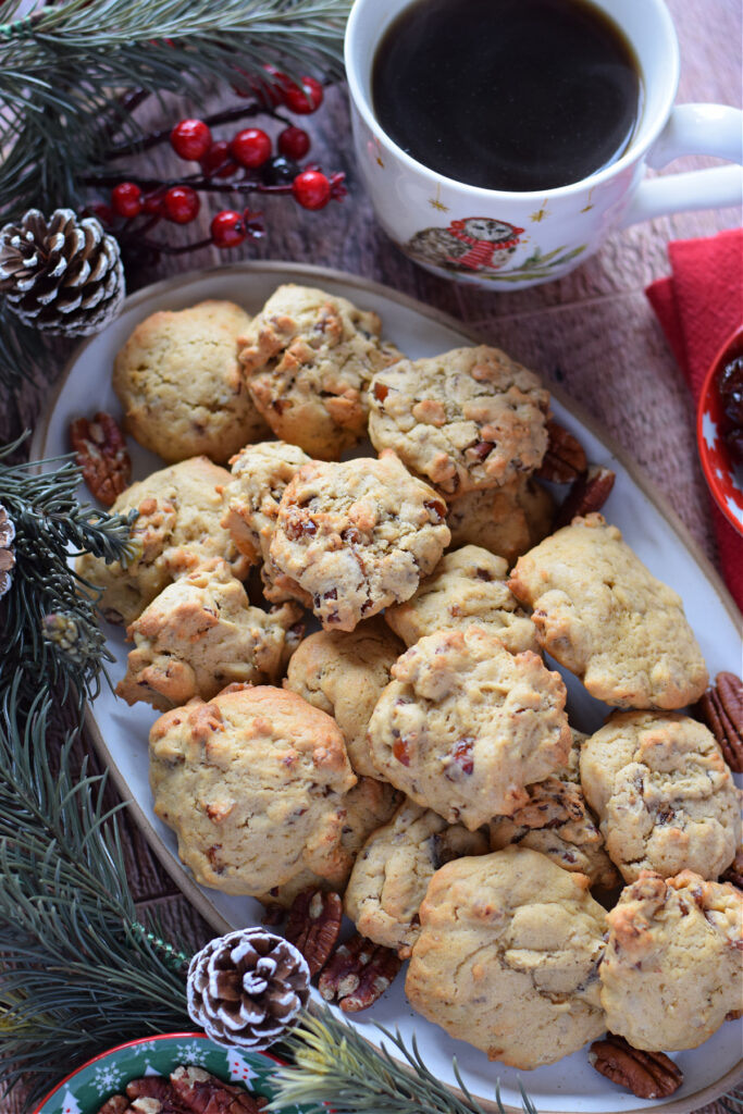 Date and pecan cookies on a cookie plate with a cup of coffee.