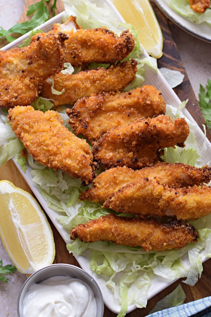 Crispy fried chicken on a white serving plate.