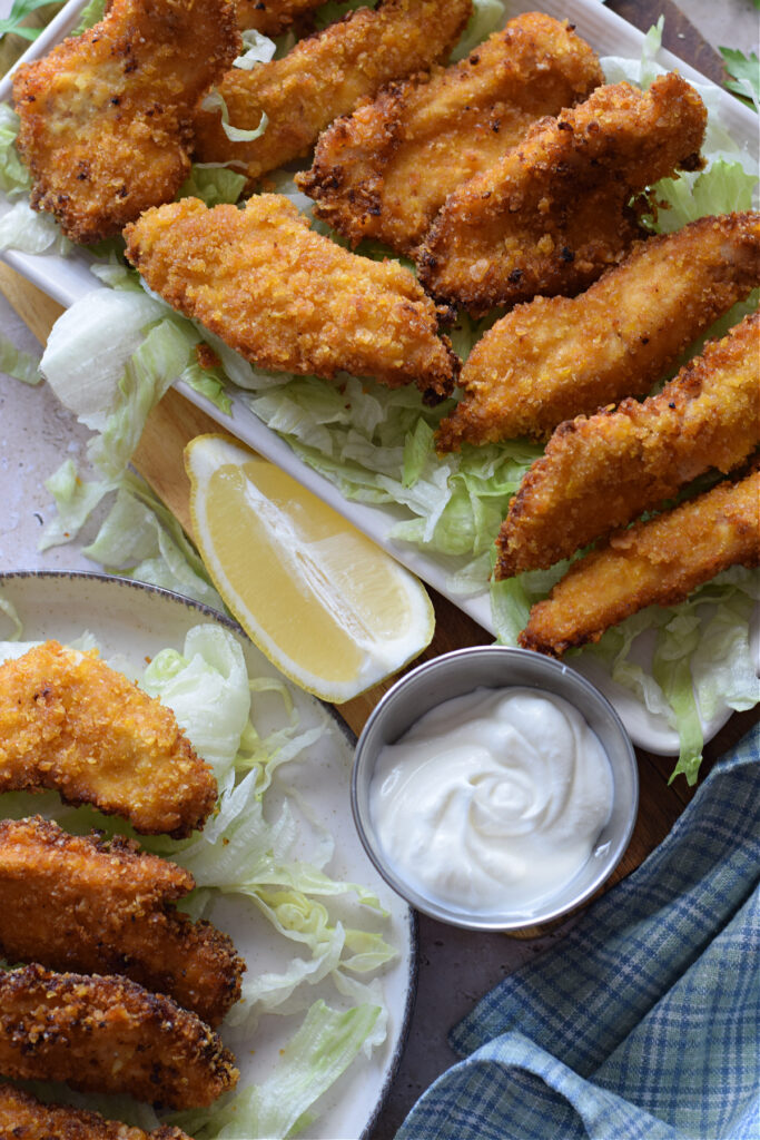 Crispy chicken strips with yogurt dip and lemon.